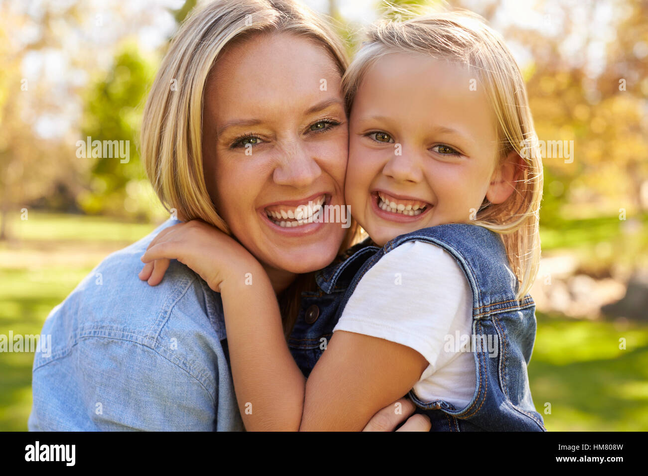 Mutter und junge Tochter lächelnd zu Kamera, hand auf Schulter Stockfoto