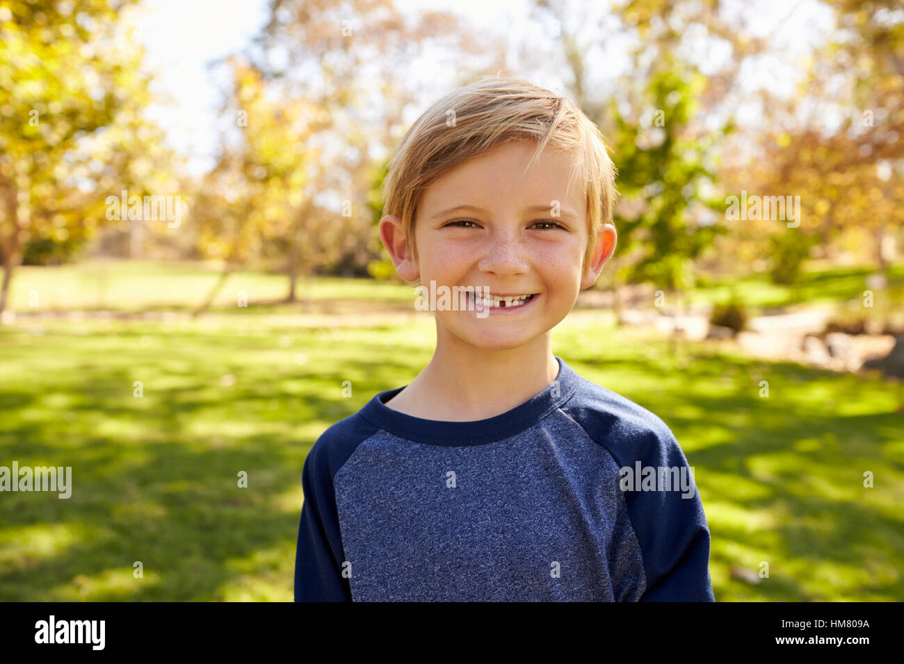 Sieben Jahre alten kaukasischen junge in einem Park lächelnd zu Kamera Stockfoto