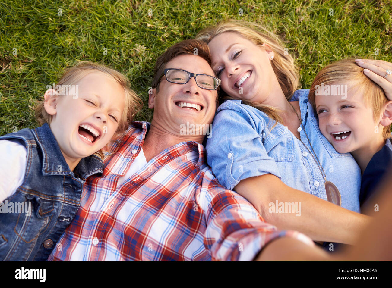 Weißen Familie liegt auf dem Rasen unter Selfie, Kamera aus Schuss Stockfoto