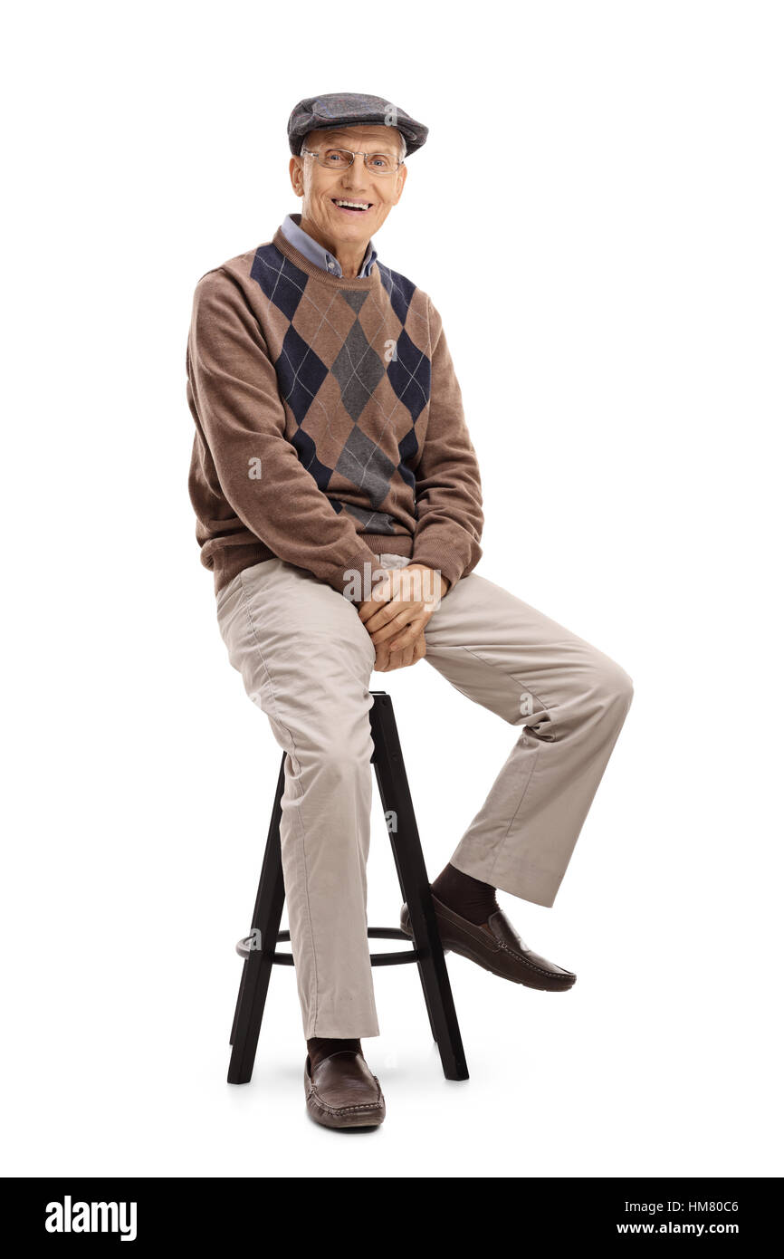 Älterer Mann sitzt auf einem Stuhl und schaut in die Kamera, die isoliert auf weißem Hintergrund Stockfoto