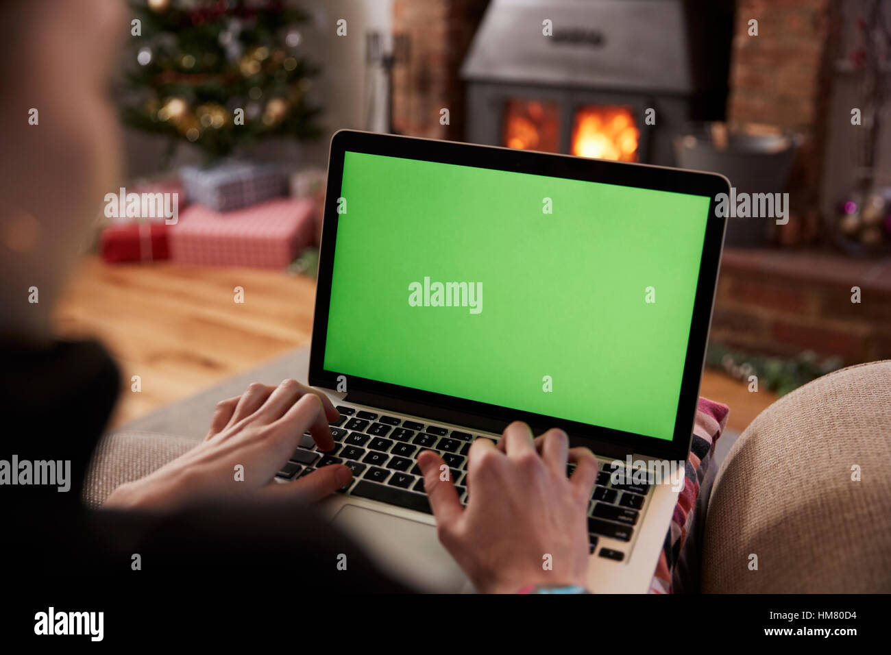 Mann mit Laptop im Zimmer für Weihnachten dekoriert Stockfoto