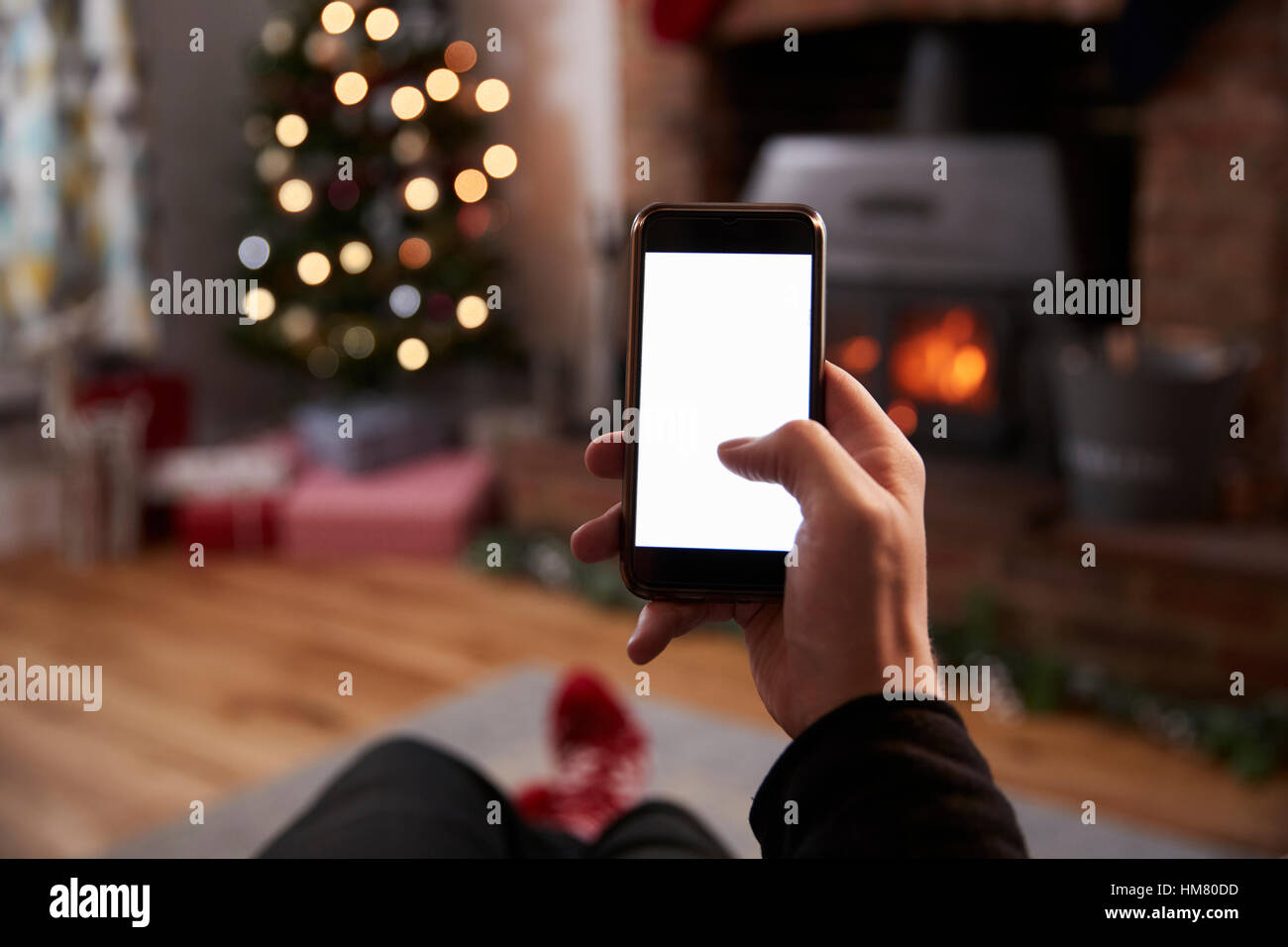 Mann mit Handy im Zimmer für Weihnachten dekoriert Stockfoto