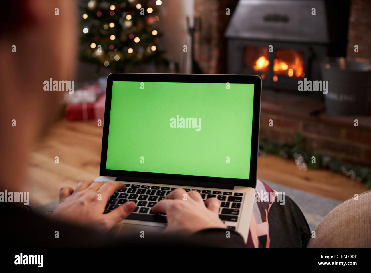 Mann mit Laptop im Zimmer für Weihnachten dekoriert Stockfoto
