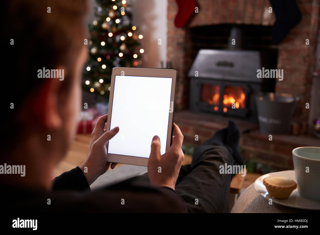 Mann mit Digital-Tablette In Zimmer dekoriert für Weihnachten Stockfoto