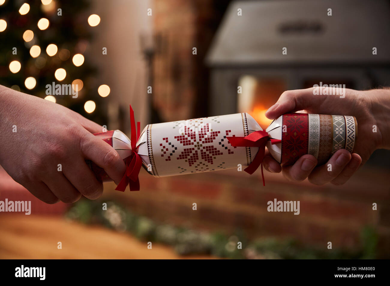 Paar ziehen Cracker im Zimmer für Weihnachten dekoriert Stockfoto