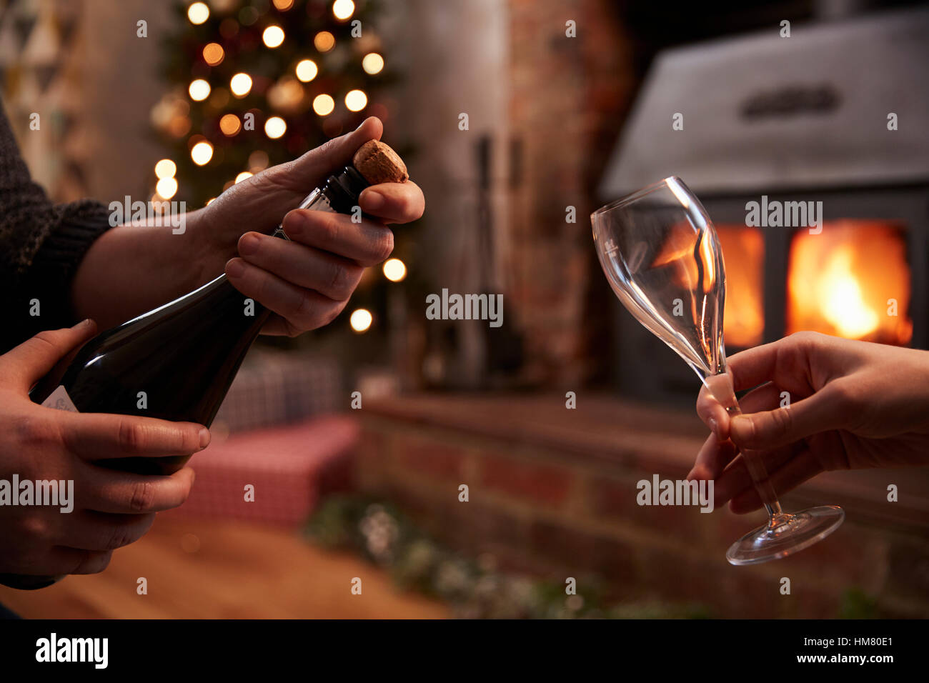 Paar Eröffnung Champagner im Zimmer für Weihnachten dekoriert Stockfoto