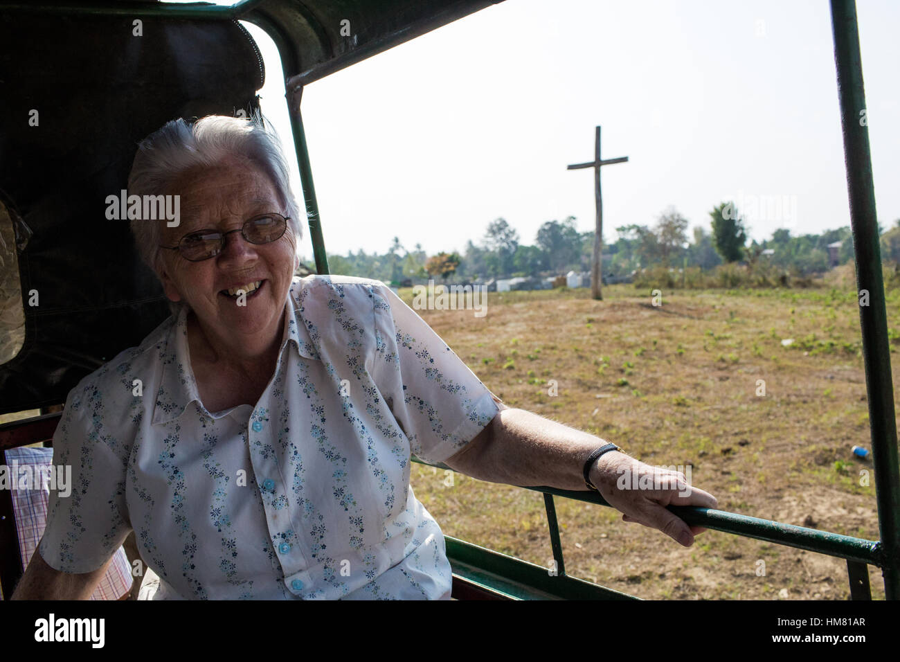 Schwester Mary - 30.03.2013 - Burma - Schwester Mary auf dem Weg zum buddhistischen Friedhof. Im Hintergrund ist ein großes Kreuz, das symbolisch Chrsitian trennt und buddhistischen Gräber. Schwester Mary aus Irland, läuft das Hope Center, eine soziale und medizinische Zentrum, finanziell unterstützt durch die katholische Kirche und die Unterstände Opfer von HIV in der Armen Region von Myitkyina im Kachin-Gebiet, Nordburma.   -Chris Huby / Le Pictorium Stockfoto