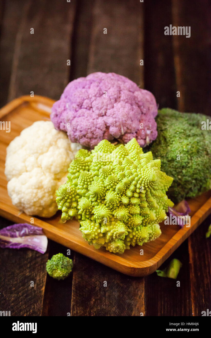 Frische Bio weiße und violette Blumenkohl, Brokkoli, Romanesco in Holzschale Stockfoto