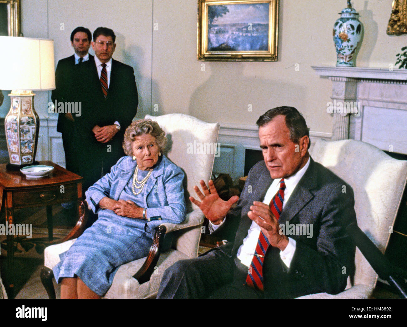 Präsident der Vereinigten Staaten George H.W. Bush spricht dem Presse-Pool, wie seine Mutter, Dorothy Walker Bush, 87, im Oval Office des weißen Hauses in Washington, D.C. während seinem ersten Tag als Präsident am 21. Januar 1989 aussieht, auf. White House Chief of S Stockfoto