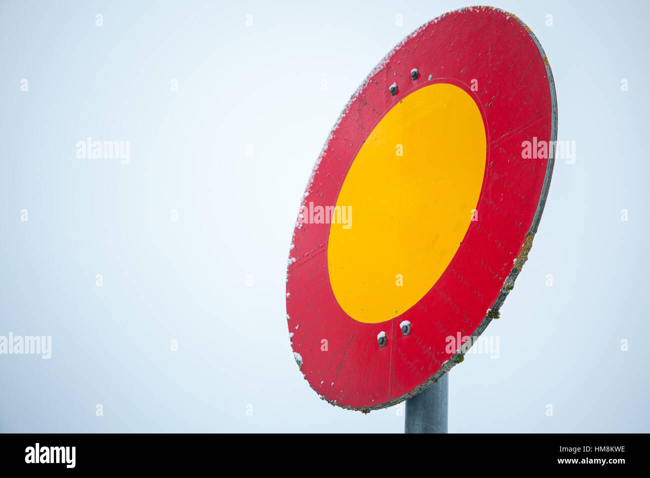 Runde rote und gelbe Stoppschild auf Metallstange über strahlend blauer Himmel Stockfoto