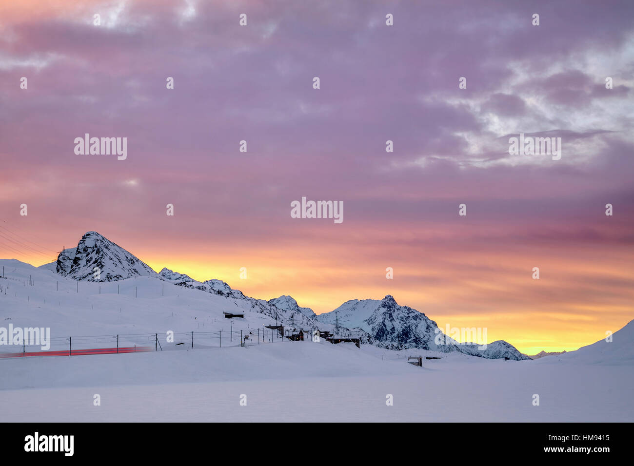 Rosa Wolken und Schnee Rahmen der Bernina Express Zug im Morgengrauen, Berninapass, Kanton Graubünden, Engadin, Schweiz Stockfoto