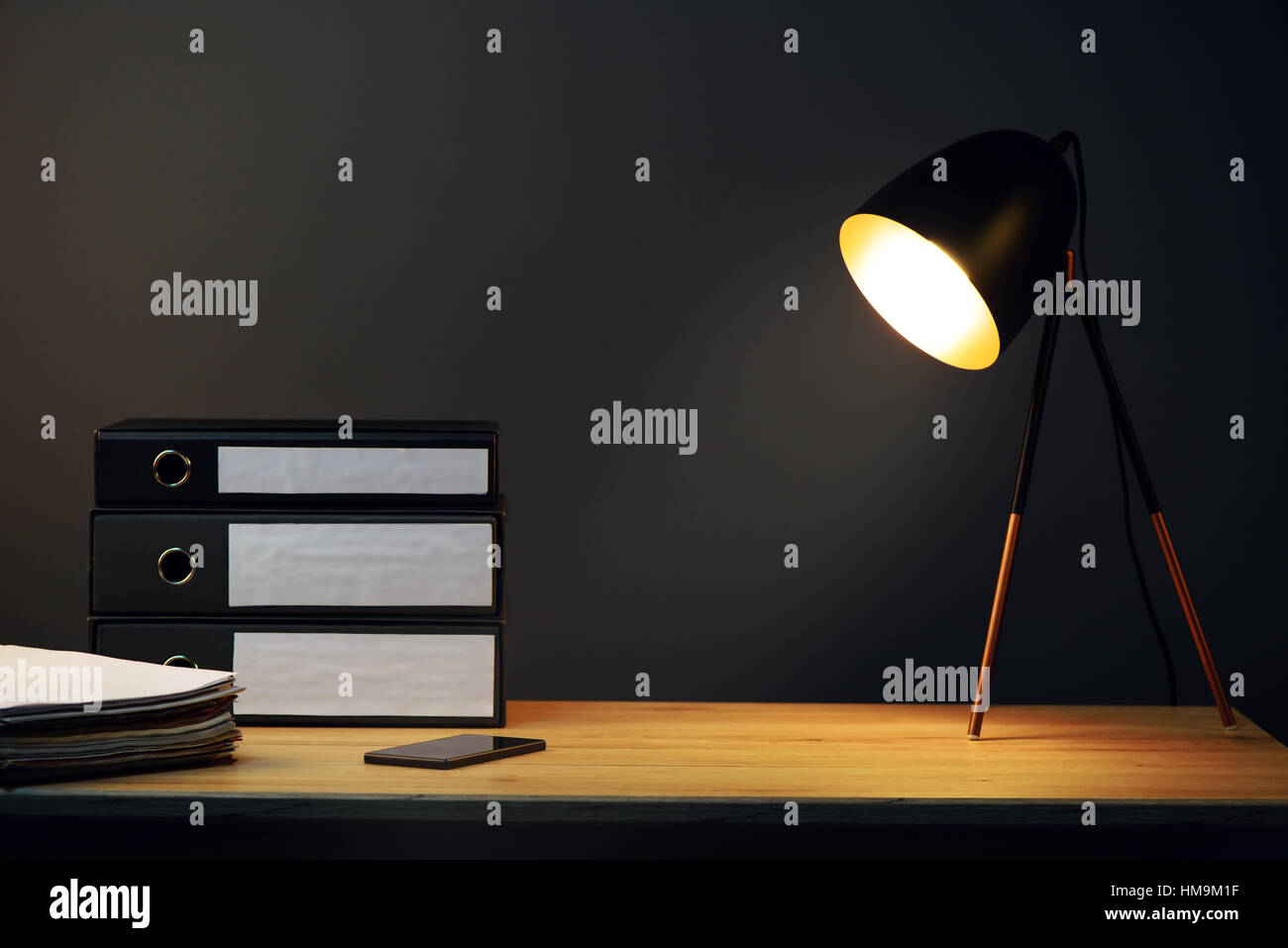 Schreibtisch mit Lampe, Ringbücher und Handy Stockfoto