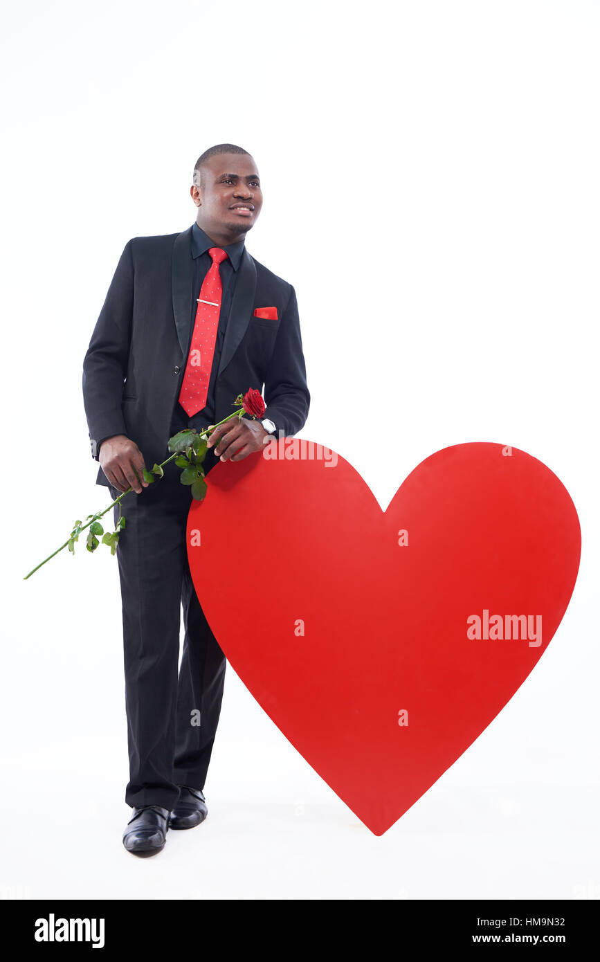 Afrikanischer Mann in schwarz mit roter rose Suite. Stockfoto