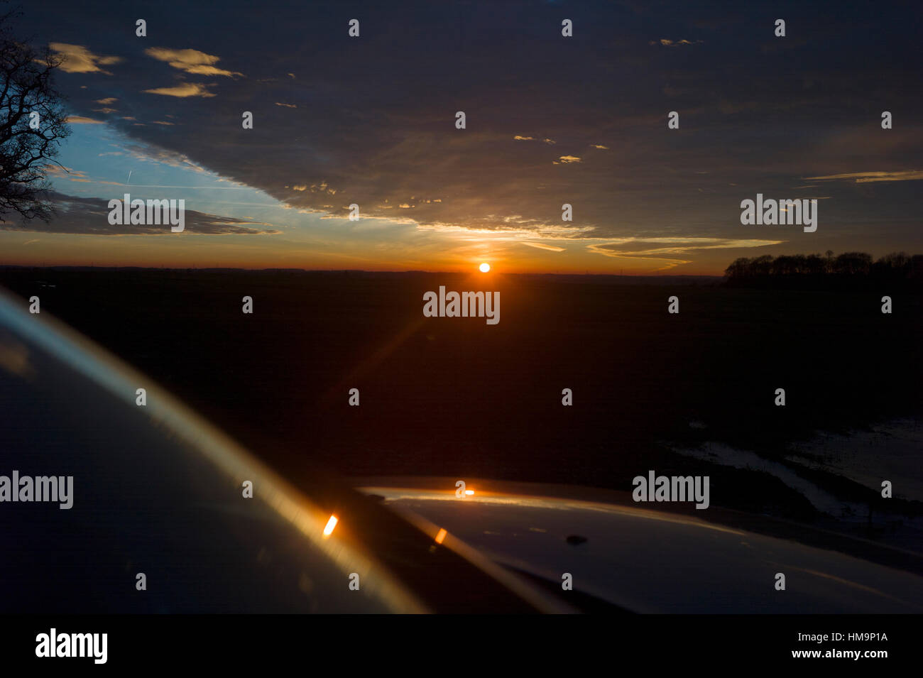 Debden North Essex, England UK. Mit der Temperatur bei Null die Sonnenuntergänge in eine Makrele Himmel und spiegelt sich in gefrorenem Eis Wasser. 18. Januar 2017 Stockfoto