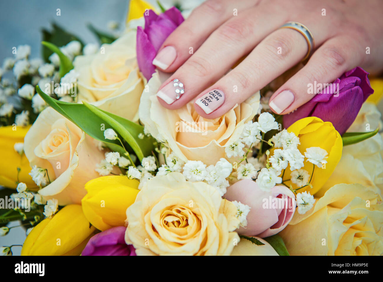 Hände mit Eheringe und bouquet Stockfoto