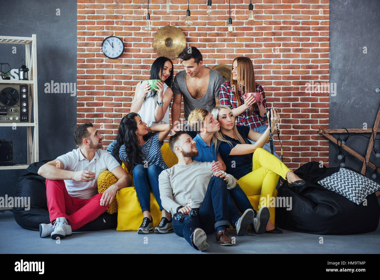 Gruppenbild der multi-ethnischen jungen und Mädchen mit bunten modische  Kleidung hält Freundin posiert auf eine Mauer, Urban-Style-Leute, die Spaß,  Konzepte über Jugend Zweisamkeit Lebensstil Stockfotografie - Alamy