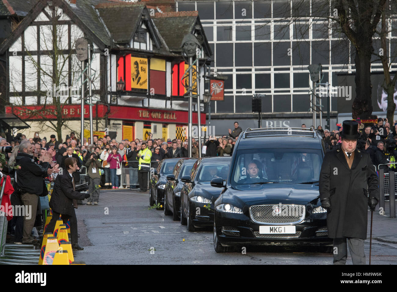 Ein Trauernder wirft Blumen bei den Leichenwagen verlässt der Sarg von Graham Taylor an Str. Marys Kirche, Watford, im Anschluss an der Trauerfeier für Graham Taylor. Stockfoto