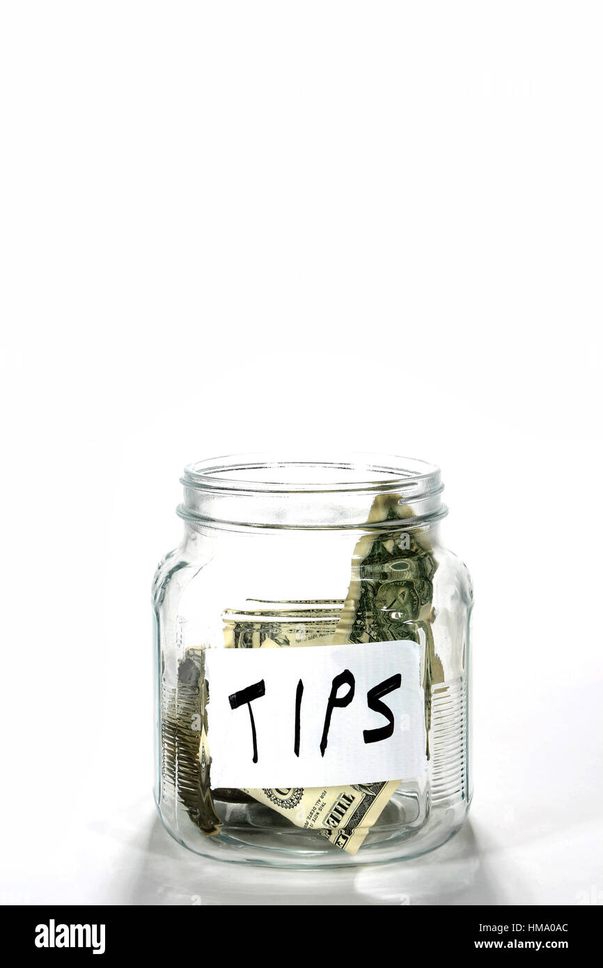 Geld Glas beschriftet Tipps hat ein paar Dollarscheine drin. Stockfoto