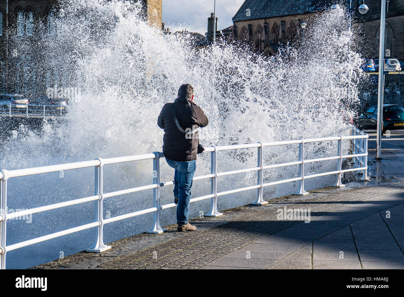 Aberystwyth Ceredigion Wales UK, Donnerstag, 2. Februar 2017 UK Wetter: ein Mann fotografiert als den starken Winden und hohen Gezeiten Vormittag bringen riesige Wellen, die in die Promenade und Meer Abwehr in Aberystwyth an der Westküste von Wales. Stark und potenziell schädlichen Gales, mit Böen von mehr als 60 km/h sind Wetternachrichten Streikrecht Teilen des südlichen Königreichs morgen Credit: Keith Morris/Alamy Live-Nachrichten Stockfoto