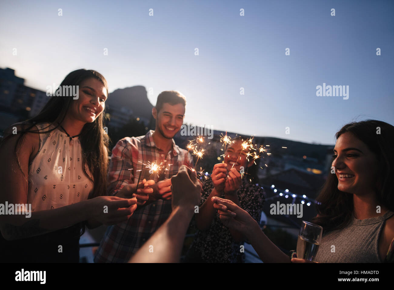 Gruppe von Freunden genießen auf der Dachterrasse-Party mit Wunderkerzen. Junge Menschen genießen Silvester. Stockfoto