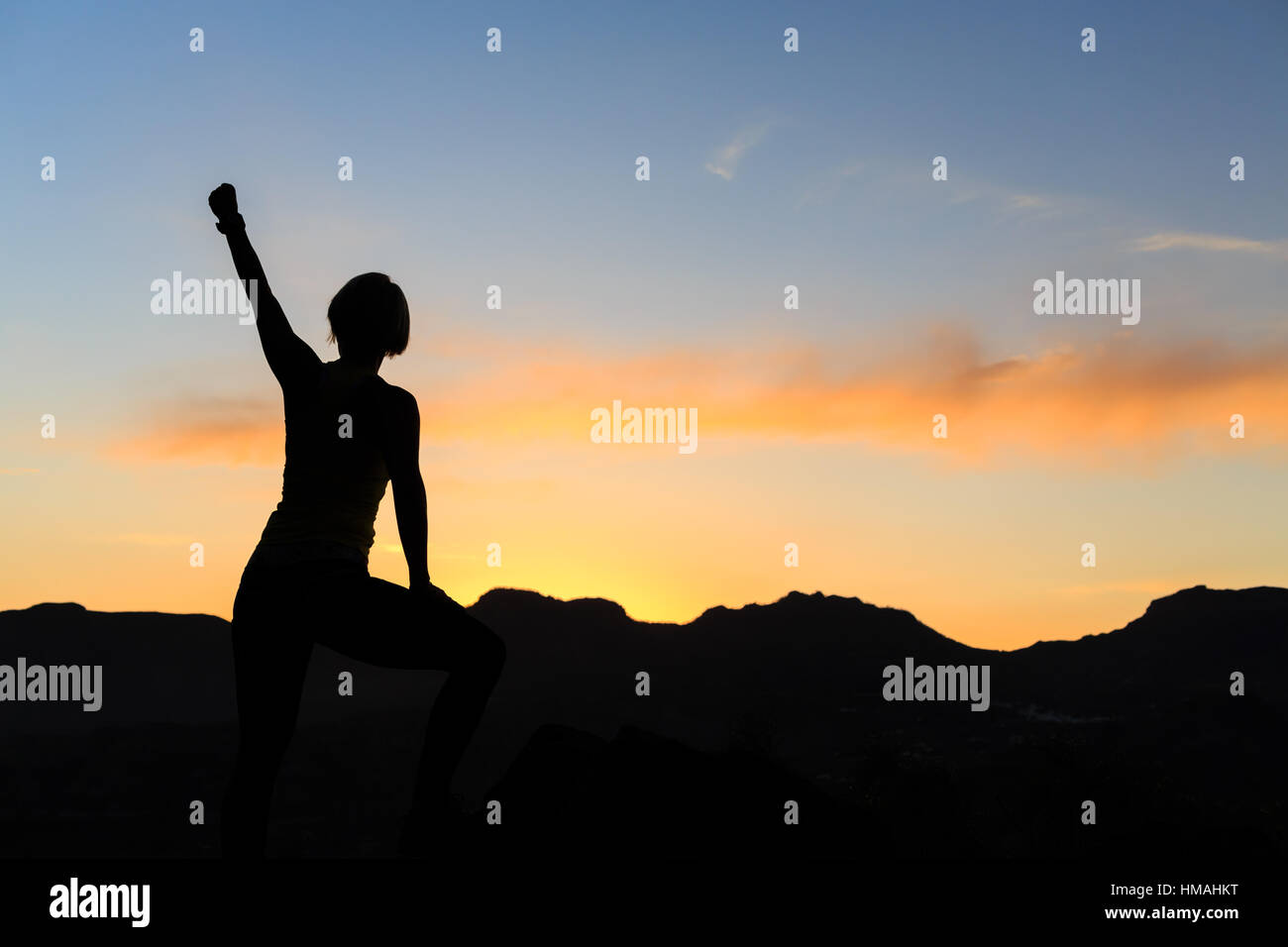 Frau Wandern Silhouette im Sonnenuntergang, Berge und Meer. Weibliche Wanderer, Bergsteiger oder Trailläufer mit Mountain Top betrachten Beauti ausgestreckten Armen Stockfoto