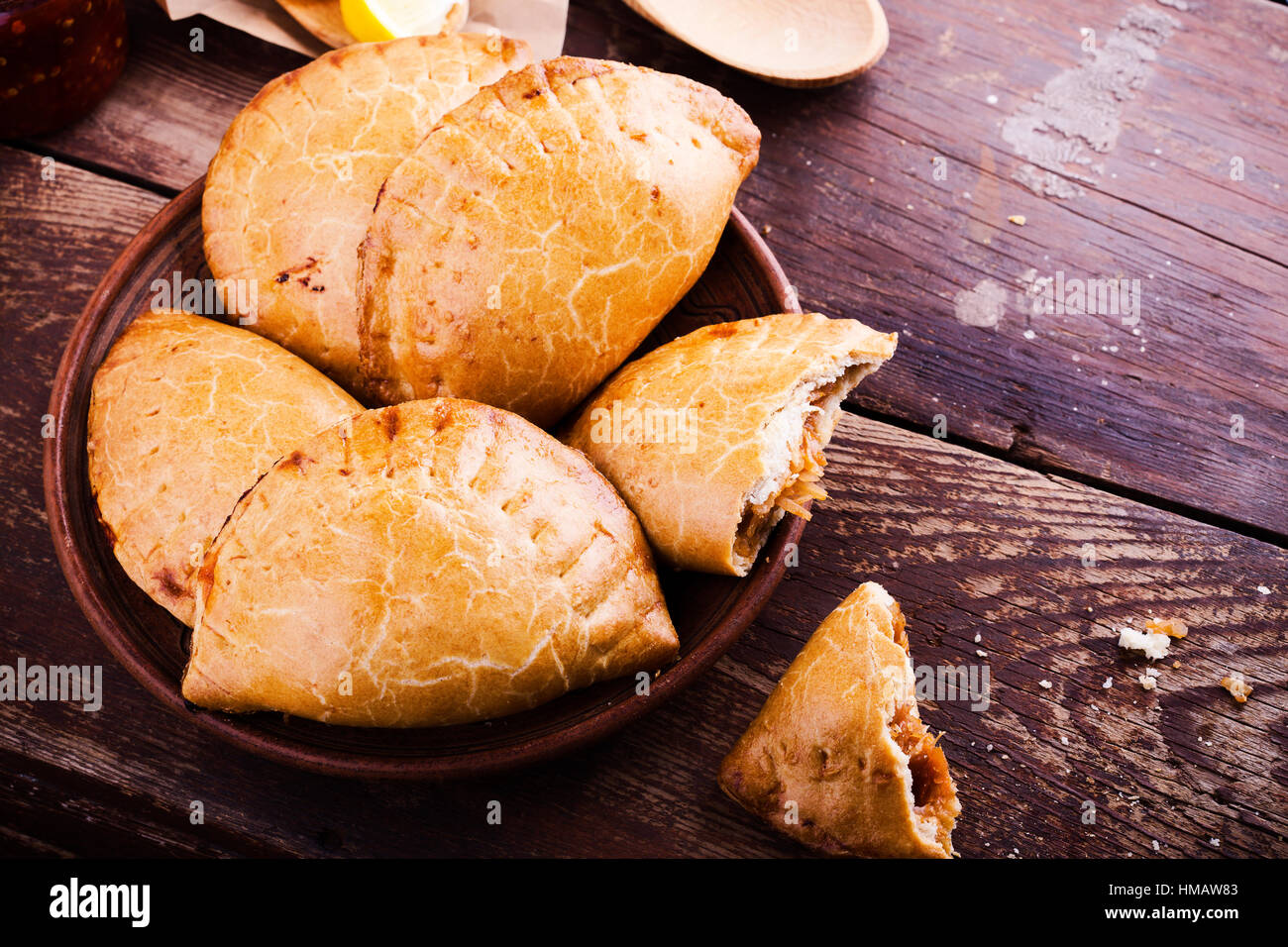 Hausgemachte gebackene vegetarische Empanadas, Latein-Amerikanisches gefüllt Gemüse Pie mit gedünstetem Kohl, Karotten, Zwiebeln, Tomaten auf rustikalen Holz Rücken Stockfoto