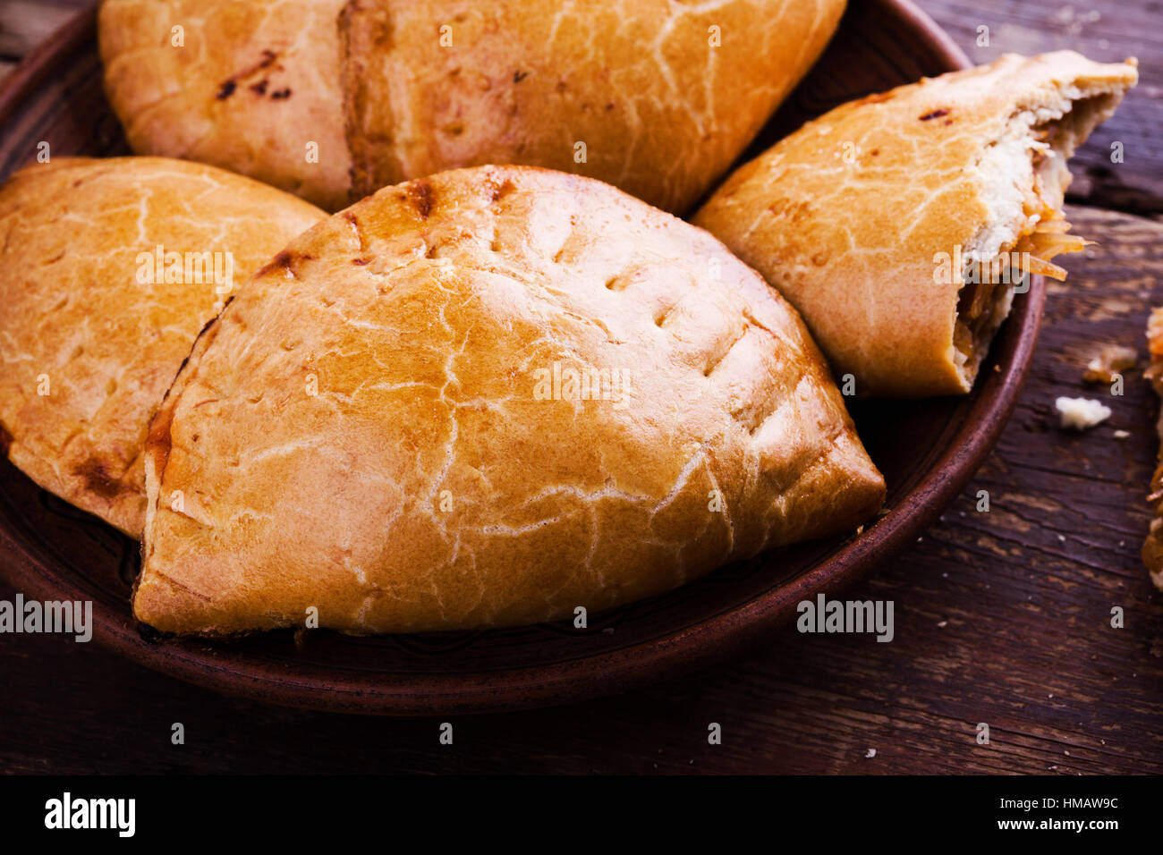 Hausgemachte gebackene vegetarische Empanadas, Latein-Amerikanisches gefüllt Gemüse Pie mit gedünstetem Kohl, Karotten, Zwiebeln, Tomaten auf rustikalen Holz Rücken Stockfoto