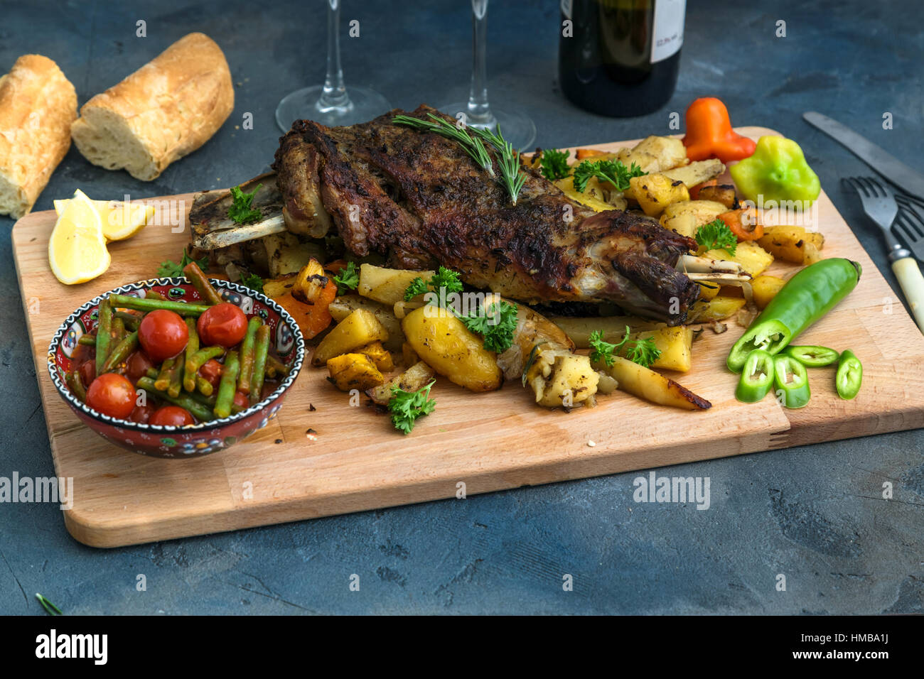 Gebratene Lammschulter auf gebackenen Kartoffeln und Karotten, Holzbrett, Ansicht von oben Stockfoto