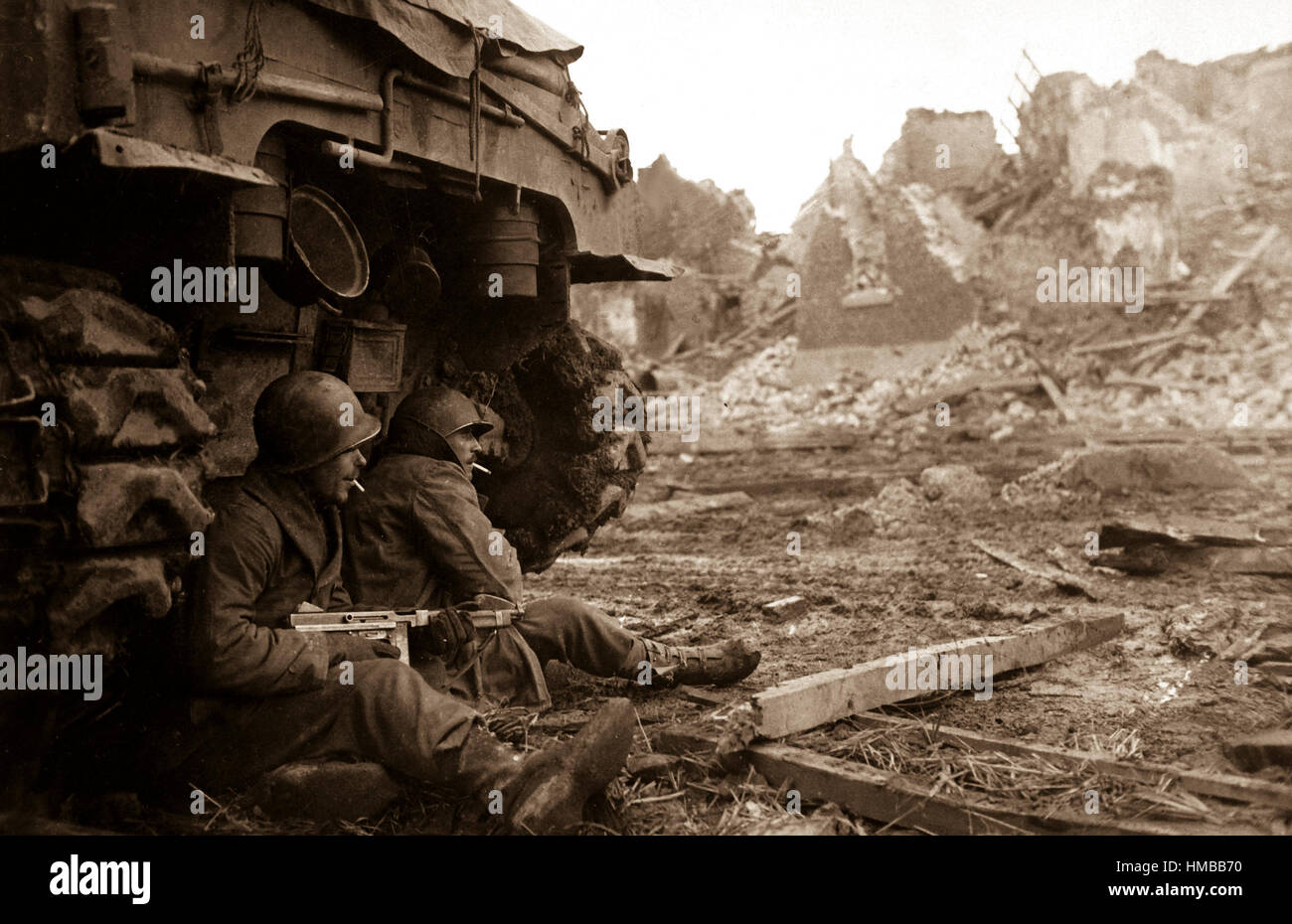 Mit deutschen Schalen schreien overhead suchen amerikanische Infanteristen Zuflucht hinter einem Tank.  Im Hintergrund sind die Ruinen der Stadt von Geich, Deutschland, die noch unter schweren Beschuss zu sehen.  11. Dezember 1944. Roberts. (Armee) NARA-DATEI #: 111-SC-197261 KRIEG & KONFLIKT BUCH #: 1090 Stockfoto