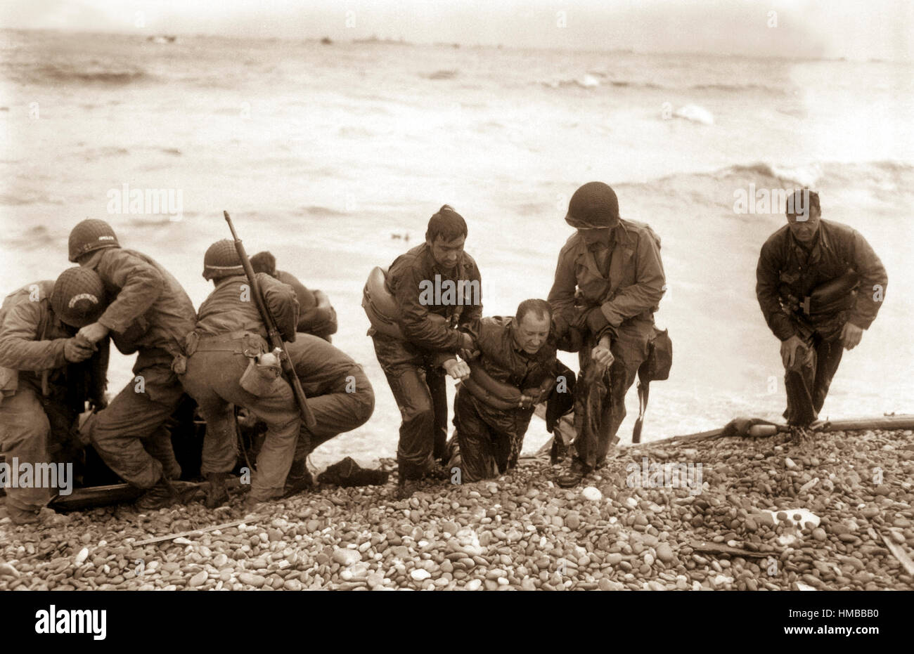 Mitglieder einer amerikanischen Landung-Partei verleihen helfende Hände für andere deren Landungsboote versenkt durch Feindeinwirkung vor der Küste von Frankreich.  Diese Überlebenden erreicht, Utah Beach, in der Nähe von Cherbourg, indem eine Rettungsinsel.  6. Juni 1944.  Weintraub.  (Armee) NARA-DATEI #: 111-SC-190366 KRIEG & KONFLIKT BUCH #: 1042 Stockfoto