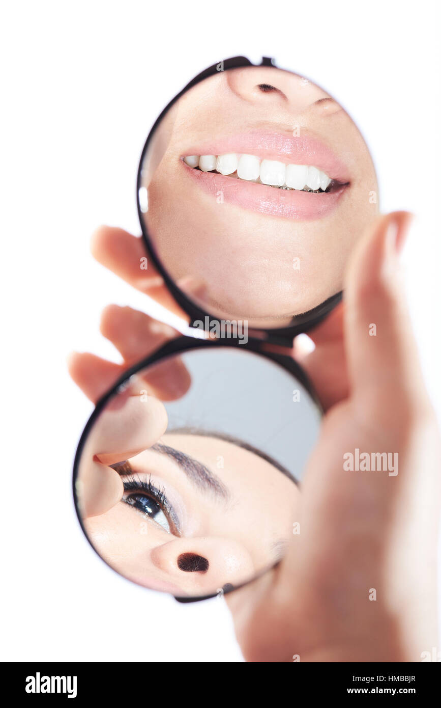 Lächeln in der Reflexion des Spiegels isoliert auf weiss hautnah Stockfoto
