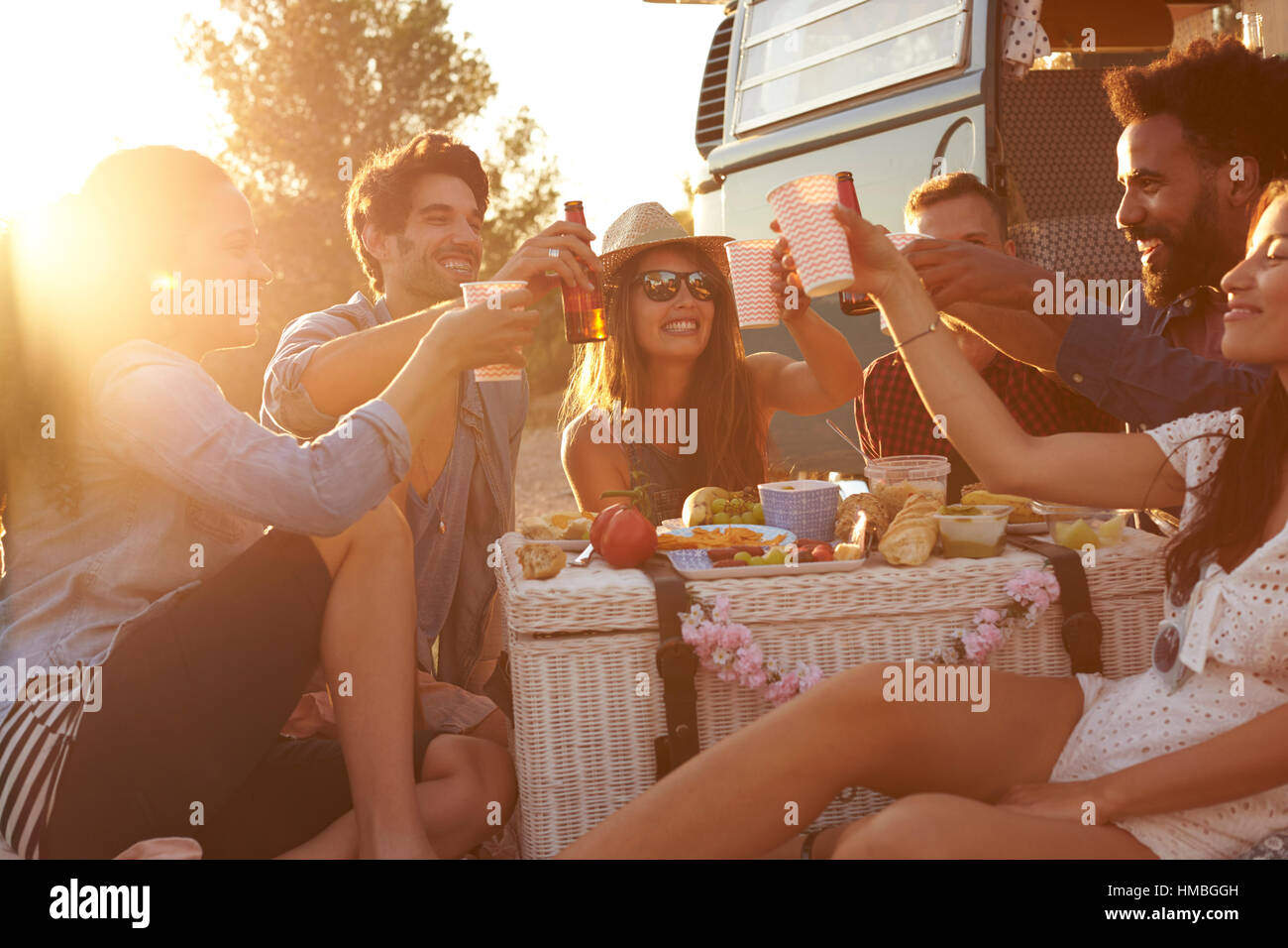 Freunde machen einen Toast bei einem Picknick neben ihrem Wohnmobil Stockfoto