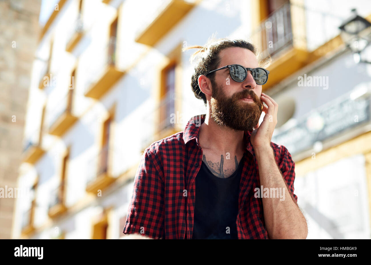 Bärtiger junger Mann in Sonnenbrille mit Telefon, Ibiza, Spanien Stockfoto