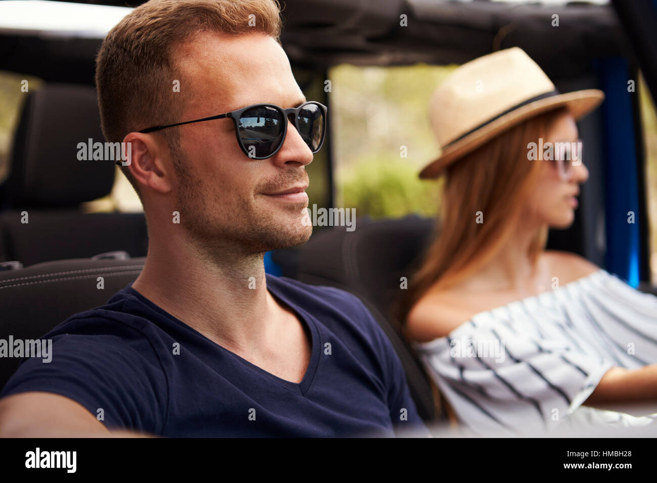 Junges Paar fahren Open Top Car auf Landstraße Stockfoto