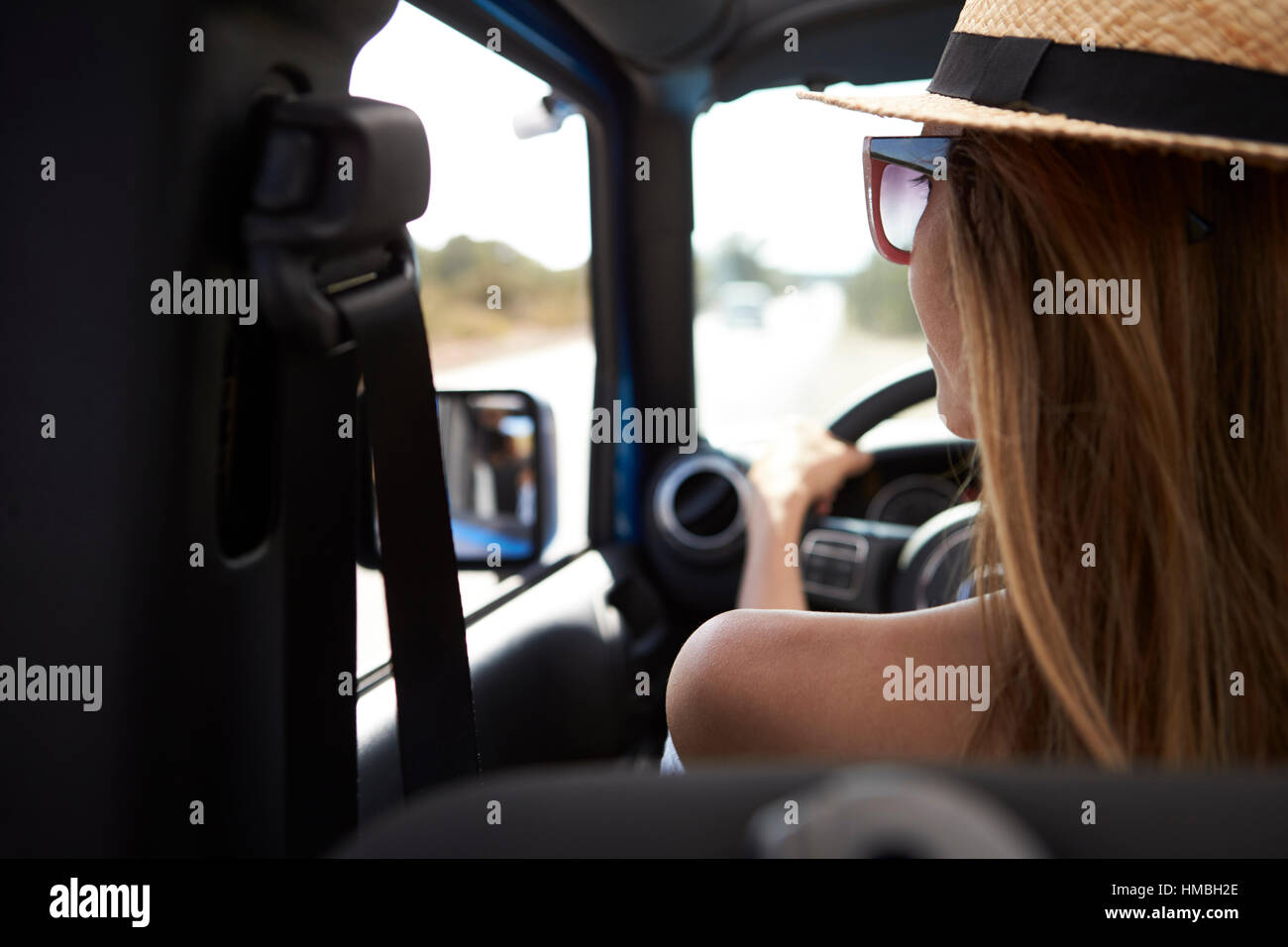 Junge Frau, die Landstraße Top Großraumwagen befahren Stockfoto