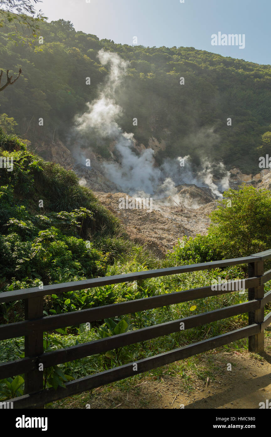 Ein kleiner Zaun in das Forground Rahmen dieses aktiven Vulkan Rauchen am Soufrière, St. Lucia. Der Rauch rollt den tropischen Regenwald Hügel hinauf. Stockfoto