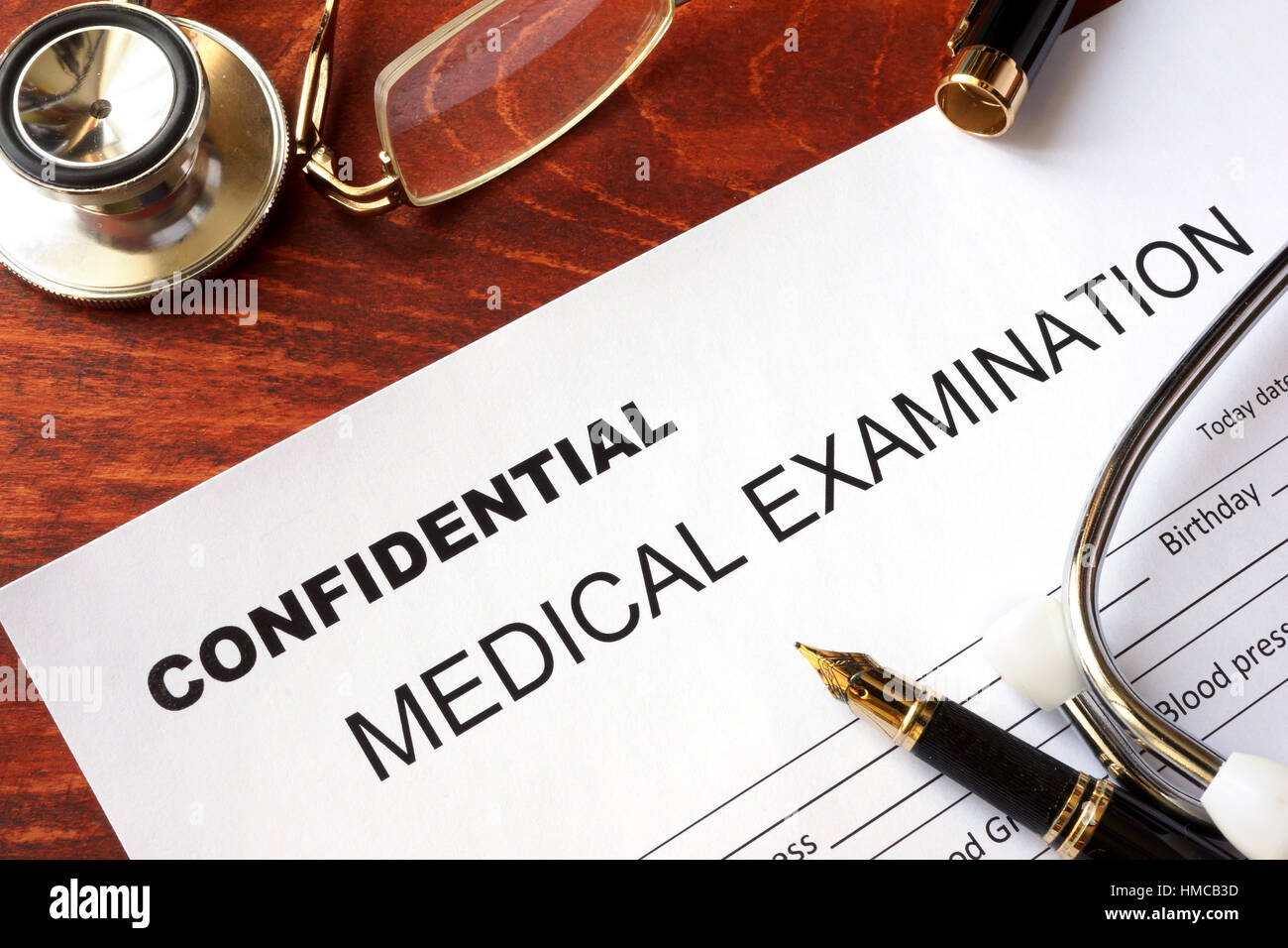 Ärztliche Untersuchung-Formular mit Titel vertraulich auf einem Tisch. Stockfoto