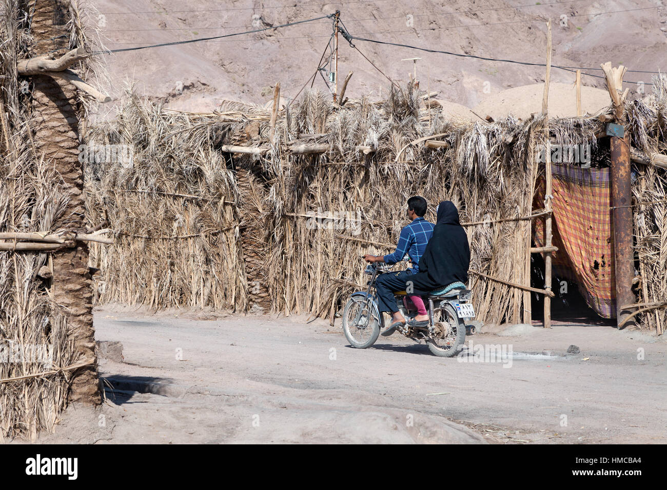 Kerman, Iran - 16. Oktober 2015: Paar auf einem alten Motorrad in einem ländlichen Dorf Kerman Region, südöstlichen Iran Stockfoto