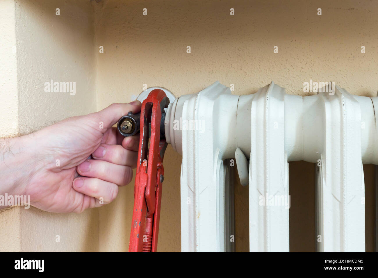 Klempner bei der Installation eines Thermostatventils an einem Kühler Stockfoto