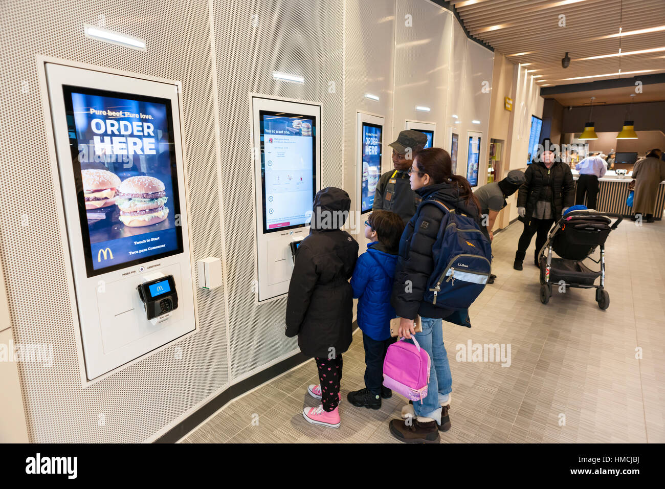 Ein Concierge unterstützt Diners bei einer digitalen Bestellung Kioske in einem Prototyp McDonald's in New York, upscaling mit minimalistischen Dekor und ein McCafe auf Mittwoch, 1. Februar 2017.  (© Richard B. Levine) Stockfoto