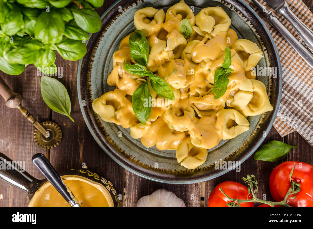 Tortellini mit Käse-Sauce, Basilikum und Kräutern Stockfoto