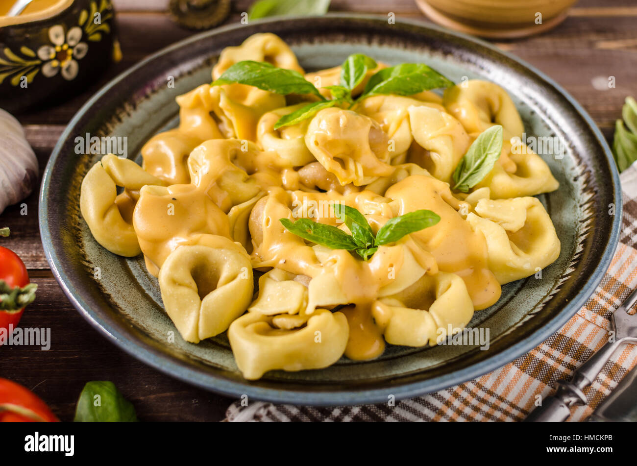Tortellini mit Käse-Sauce, Basilikum und Kräutern Stockfoto