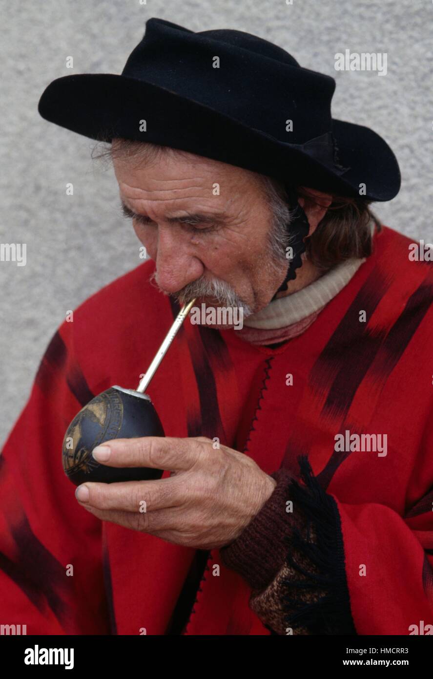 Gaucho trägt einen Filzhut und Poncho trinken mate, Infusion von Yerba Mate-Blätter, Argentinien. Stockfoto