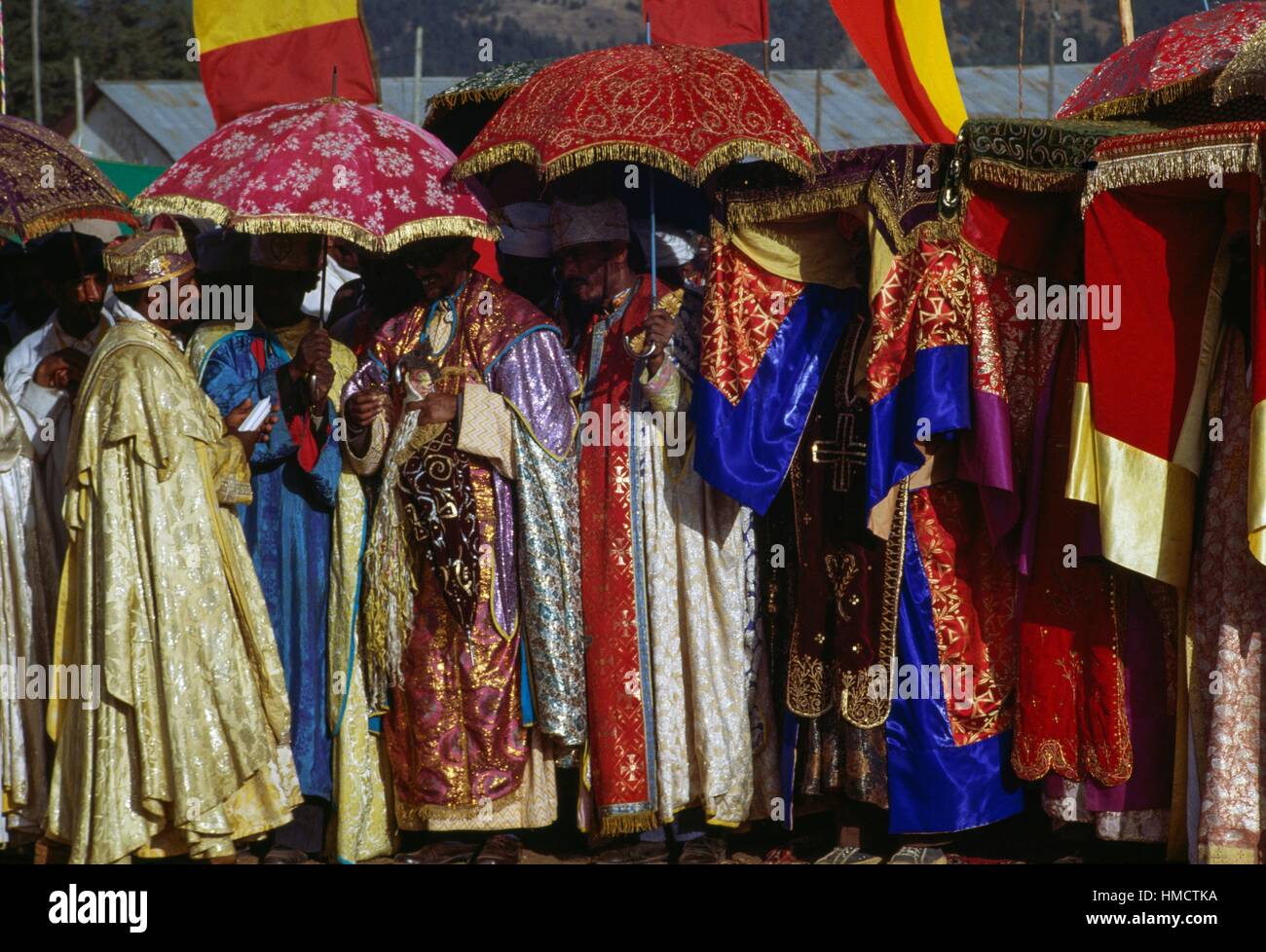 Priester tragen aufwändige Kleidung und Beschattung selbst mit Regenschirmen während Timkat Festival, koptische Epiphanias, Äthiopien. Stockfoto