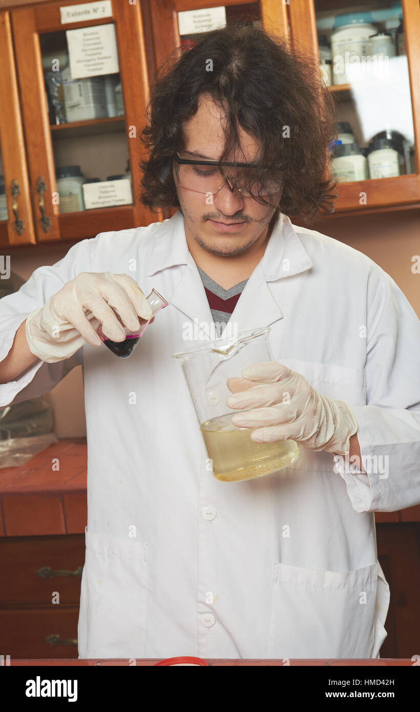 junge Chemiker mischen Röhren im Labor während des Studiums Stockfoto