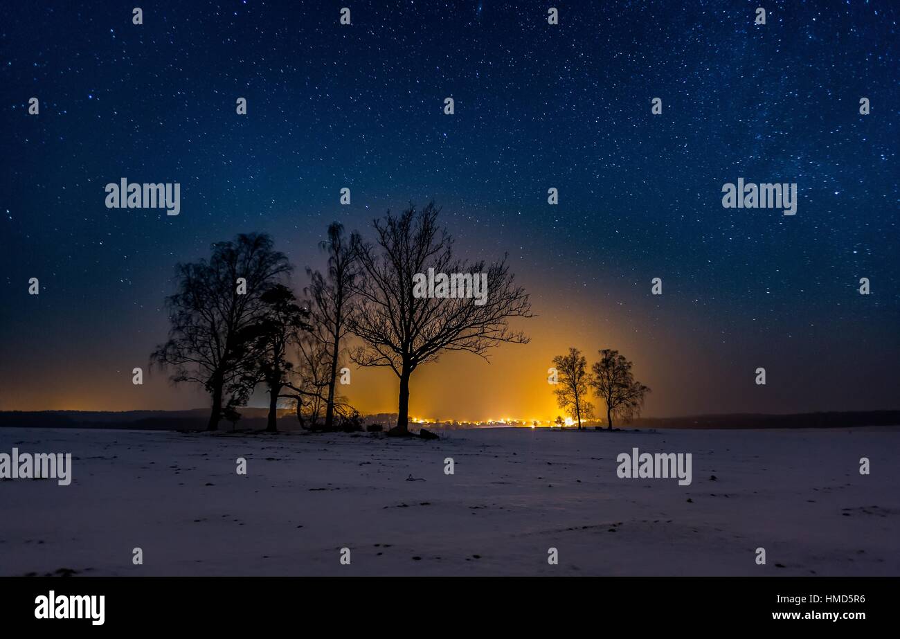 Nacht Landschaft mit Sternenhimmel, Winter Feld und Fernlichter vom Dorf. Stockfoto