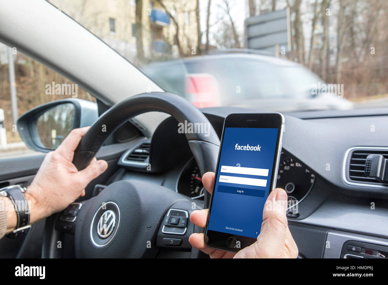 Ein Autofahrer ist ein Handy, Smartphone, mit, während der Fahrt des Autos, Stockfoto