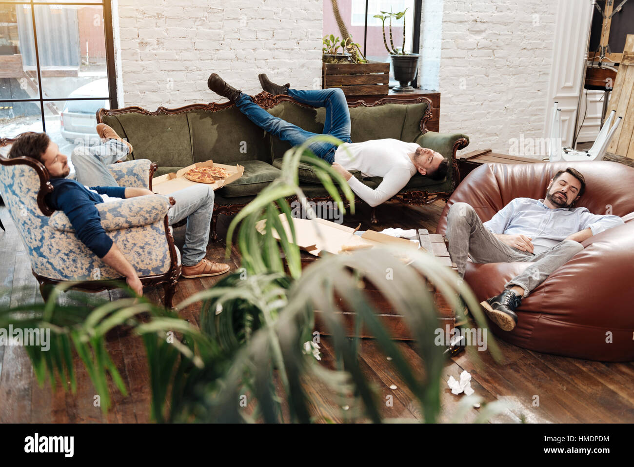 Schöne attraktive Männer schlafen im Wohnzimmer Stockfoto