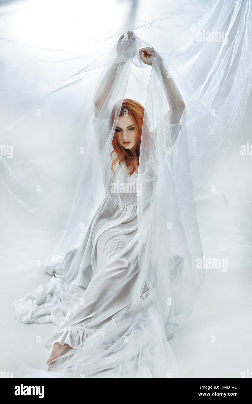 Rothaarige Mädchen Frau in weißes Tuch, abstrakte Umgebung Stockfoto