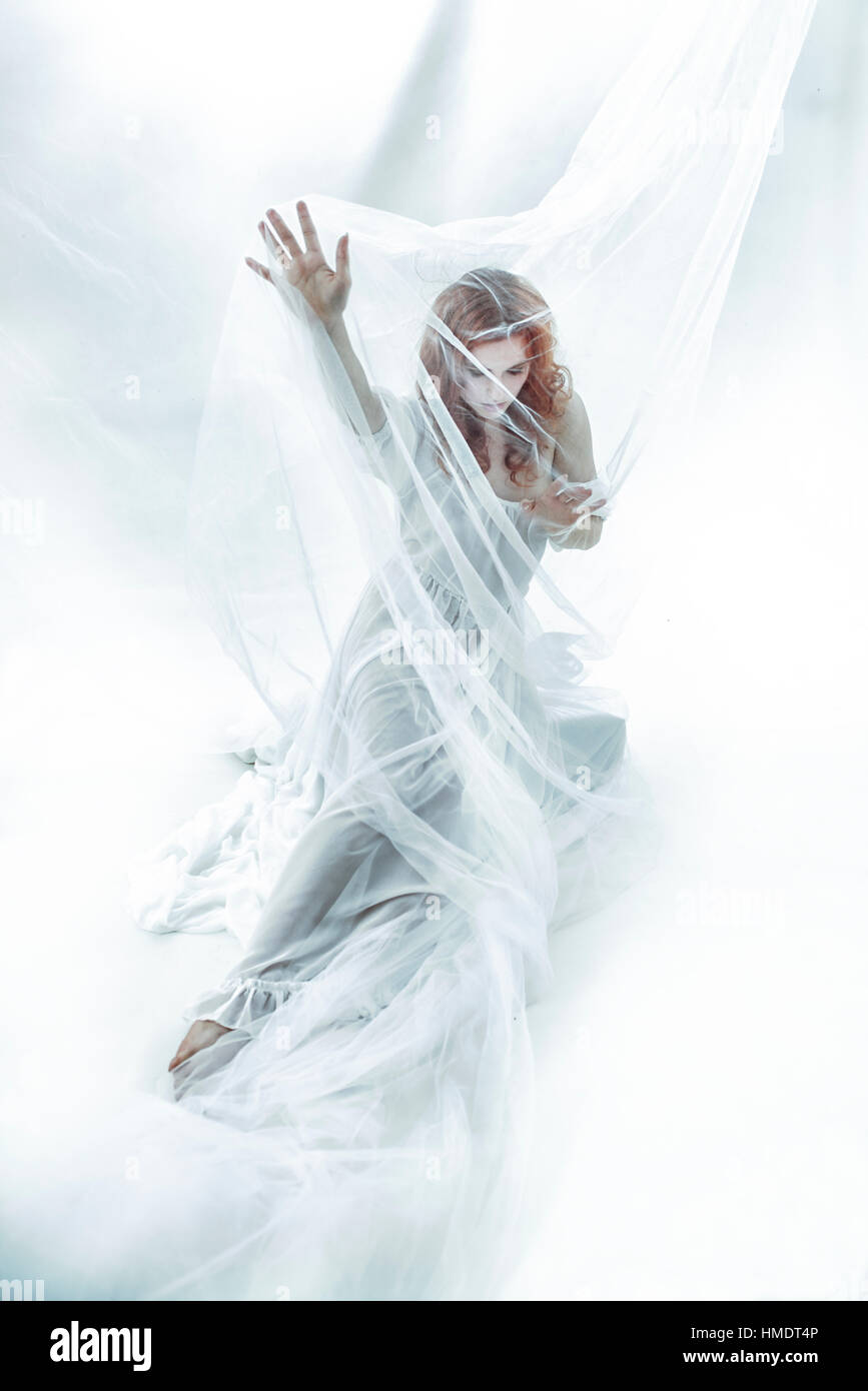 Rothaarige Mädchen Frau in weißes Tuch, abstrakte Umgebung Stockfoto